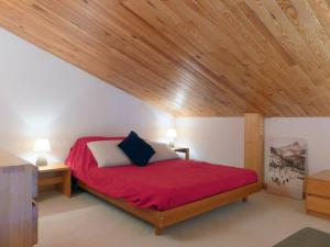 メリベルにあるRésidence Aiguille Du Fruitの木製の天井のベッドルーム1室(赤いベッド1台付)