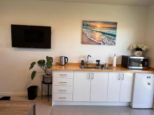 a kitchen with a sink and a microwave at Sea Escape in Whitianga