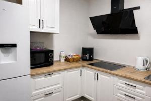 a kitchen with white cabinets and a black microwave at Apartamento EL LUCENTINO in Lucena +6 photos