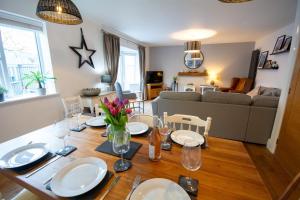 a dining room with a table and a living room at Pine Cones in Rhoscolyn