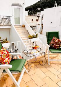 a balcony with chairs and a table with fruit on it at Casa Maddy Anacapri in Anacapri