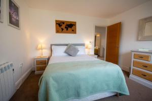a bedroom with a bed and two night stands and two lamps at Pine Cones in Rhoscolyn