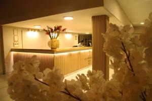 a lobby with a counter with a vase of flowers at Hotel Rodadero Beach Blue in Santa Marta +36 photos