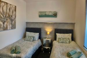 a bedroom with two beds and a lamp at 5 Sea Spray in Burnham on Sea