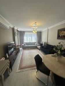 a living room with a couch and a table at Konyaaltı gürsu denize sıfır sahilde full eşyalı lüks daire in Antalya