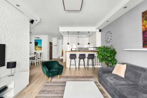 a living room with a couch and a kitchen at Wilanów Cinema Apartment in Warsaw