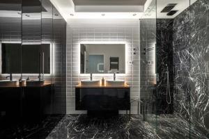 a bathroom with two sinks and a mirror at Wilanów Cinema Apartment in Warsaw +19 photos