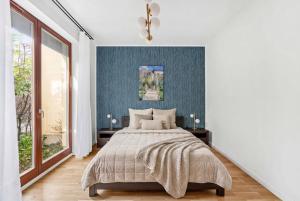 a bedroom with a bed and a blue wall at Wilanów Cinema Apartment in Warsaw