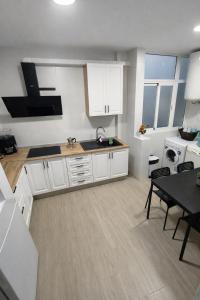 a kitchen with white cabinets and a dining table at Apartamento EL LUCENTINO in Lucena
