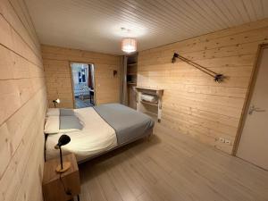 a bedroom with a bed in a room with wooden walls at Appartement la Tûte centre Laruns in Laruns