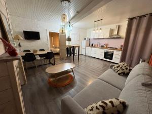 a living room and kitchen with a couch and a table at Appartement la Tûte centre Laruns in Laruns