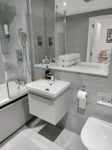 a white bathroom with a sink and a toilet at Stylish studio apartment in Olton
