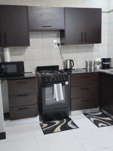 a kitchen with a black stove and cabinets at DailyPunch Apartment in Kitwe