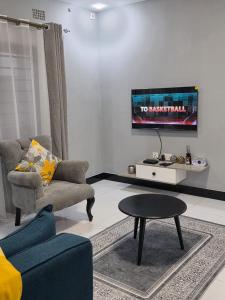 a living room with a couch and a table at DailyPunch Apartment in Kitwe +2 photos