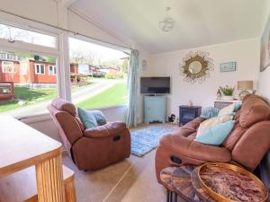 a living room with two chairs and a television at Chalet 23 Erw Porthor in Tywyn