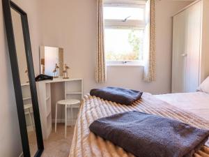 a bedroom with a bed with two pillows on it at Chalet 23 Erw Porthor in Tywyn