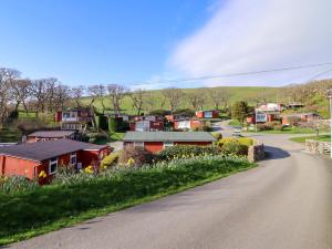 a small village with houses and flowers on the side of a road at Chalet 23 Erw Porthor in Tywyn