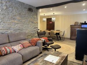 a living room with a couch and a stone wall at Caserio Uletza in Rigoitia