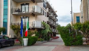 a building with two flags on the side of it at Rama Palace Hotel in Casalnuovo di Napoli