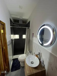 a bathroom with a sink and a toilet and a mirror at Dulce Hogar in Manta