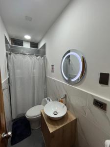 a bathroom with a white toilet and a mirror at Dulce Hogar in Manta