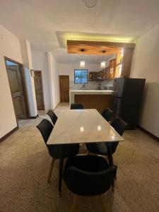 a dining room with a table and chairs and a kitchen at Dulce Hogar in Manta