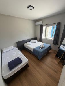 a bedroom with two beds and a window at Esquina 8 Apart in São José