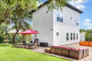 a patio with a table and a red umbrella at Pitch Perfect in Canyon Lake