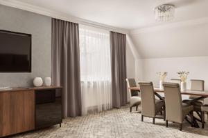 a dining room with a table and chairs and a television at Hotel Sylwia in Sośnicowice