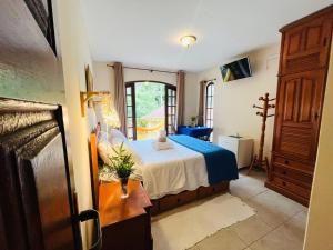 a bedroom with a bed in a room with a window at Espaço Vida Mury - Casa Mara in Nova Friburgo