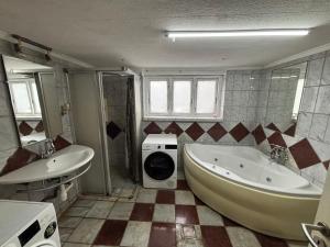 a bathroom with a tub and a sink and a washing machine at Cosy Family Basement Apartment in Copenhagen Søborg with Jacuzzi in Søborg +37 photos
