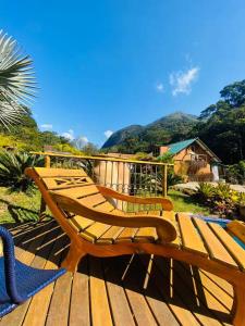 a wooden bench sitting on top of a wooden deck at Chalé - Refúgio Serra das Águas in Araras Petropolis