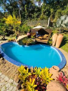 a large blue swimming pool in a yard at Chalé - Refúgio Serra das Águas in Araras Petropolis