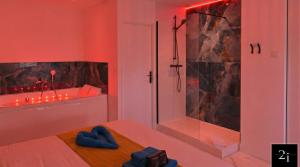a bedroom with a shower and a bed with blue towels at LE 21 - Suite SPA Premium - Jacuzzi Privatif & Vue Rhône in Vienne