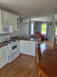 a kitchen with white appliances and a dining room at Nice and cozy in Dalhousie