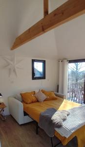 a bed in a room with a couch and a window at Cabane Cozy & Calme in Janville +3 photos