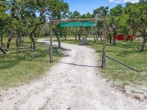 a dirt road with a gate with a sign on it at Windmill Ranch - Terra Casita #2 in Wimberley
