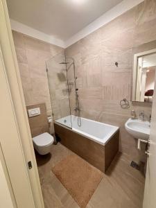 a bathroom with a tub and a toilet and a sink at Tower II in Banja Luka