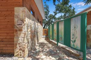 a stone wall with a sign on it next to a building at Windmill Ranch - Terra Casita #2 in Wimberley