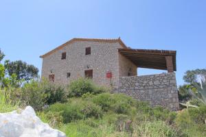 an old stone building on a hill with grass at Villa Katerina in Chania