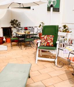 a living room with a green chair and a table at Casa Maddy Anacapri Yellow Room in Anacapri