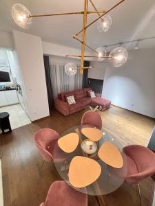 a living room with a glass table and pink chairs at Tower II in Banja Luka +22 photos