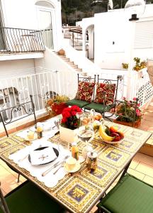 a table on a balcony with food on it at Casa Maddy Anacapri Yellow Room in Anacapri +5 photos