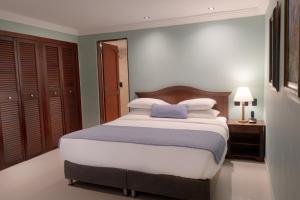 a bedroom with a large bed with a blue pillow at Hotel Faranda Express Puerta Del Sol Barranquilla, A Member of Radisson Individuals in Barranquilla