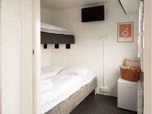 a bedroom with a bed and a tv on a wall at Budget Mobile House in Faroe Islands in Strendur