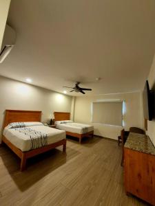 a bedroom with two beds and a ceiling fan at Hotel Baja in Tijuana +3 photos