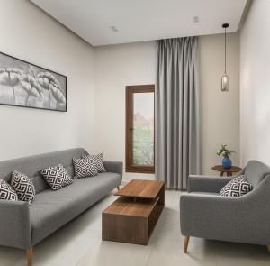 a living room with two couches and a coffee table at Sleep Inn Apart-Hotel in Cairo