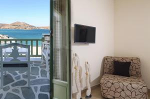 a room with a chair and a television on a balcony at Villa Isabella in Naousa