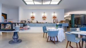 a dining room with tables and chairs and a kitchen at Grand Hotel Menaggio in Menaggio