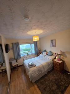 a bedroom with a large bed and a window at Antrim Heights B&B Panoramic Views & Free Parking in Antrim +9 photos